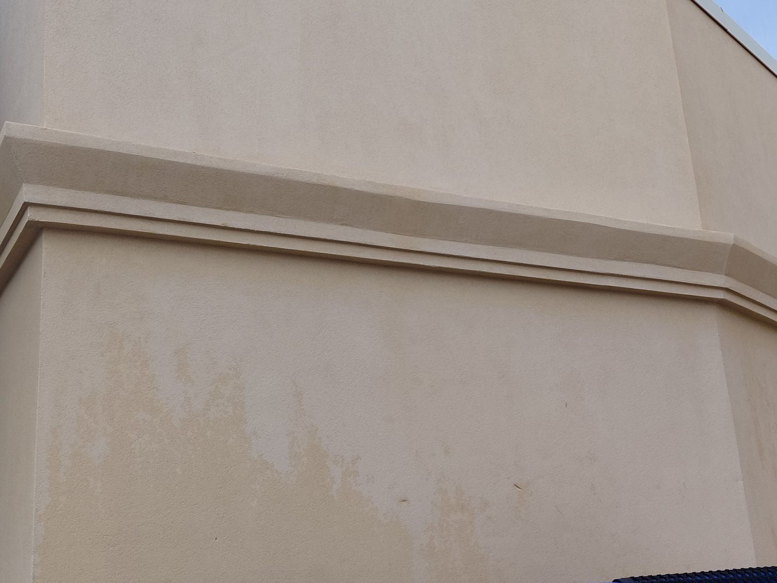 The same stucco wall, uniformly clean after soft washing